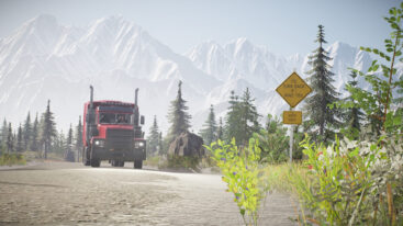 A red truck drives down a road with a sign facing away from the driver that says 