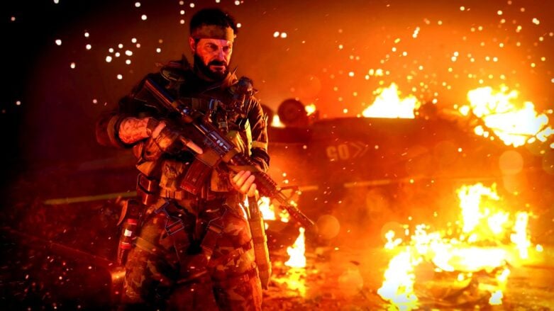 Operador de Call Of Duty Black Ops Cold War con arma cerca de los escombros y el fuego