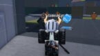 Roblox Fate Trigger Avatar Wearing Silver Helmet Black Clothes Black Sniper On Back Near A Blue Floating Question Mark Box And Orange Dummies