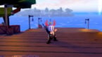 Roblox Fusion Piece Avatar Wearing Silver Helmet Black Clothes Two Giant Swords On Back Punching On Wooden Dock With Sea And Island Behind